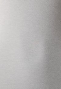 Tessuto grigio chiaro con una trama liscia, caratterizzato da una leggera lucentezza e un fine motivo a costine. La superficie appare morbida e uniforme.