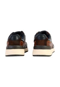Sneaker in pelle marrone e blu navy con suola imbottita, forma arrotondata, dettagli testurizzati e cuciture a contrasto. Vista posteriore.