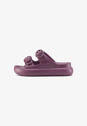 Sandalia morada de tipo slip-on con dos tiras ajustables con hebilla y suela gruesa, diseñada para uso casual y comodidad.