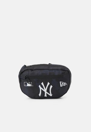Czarna saszetka na pas z przednią kieszenią na suwak, białym logo New York Yankees, emblematem MLB i logo flagi New Era na przednim panelu.