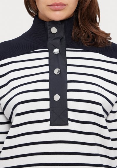 Stripet genser i hvitt og marineblått, med høy krage, fire metalliske knapper og teksturert stoff med logodetalj.