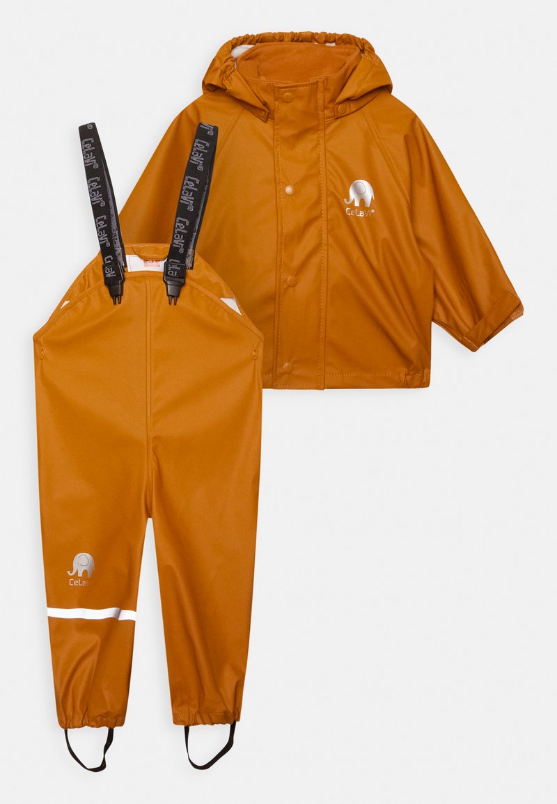 Vattentät orange regnjacka med huva och matchande byxor. Har reflekterande ränder och justerbara remmar. Materialet är slätt och hållbart.