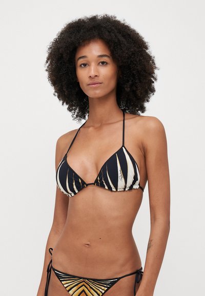 Haut de bikini à rayures noires et blanches avec un lien au dos. Doté d'un tissu texturé et de bonnets triangulaires. Bas de bikini assorti avec un motif géométrique.
