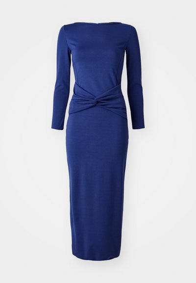 Μπλε ναυτικού μακρυμάνικο φόρεμα με στρογγυλή λαιμόκοψη, που διαθέτει λεπτομέρεια από κομμένο κόμπο στη μέση και εφαρμοστή σιλουέτα μέχρι το στρίφωμα.