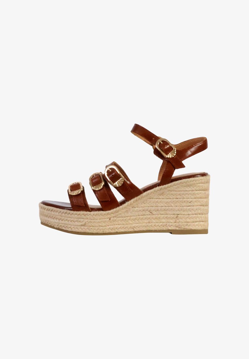 Sandale compensée en cuir marron avec trois sangles réglables, boucles dorées et un talon enroulé de jute. La semelle est plate et texturée pour une meilleure adhérence.