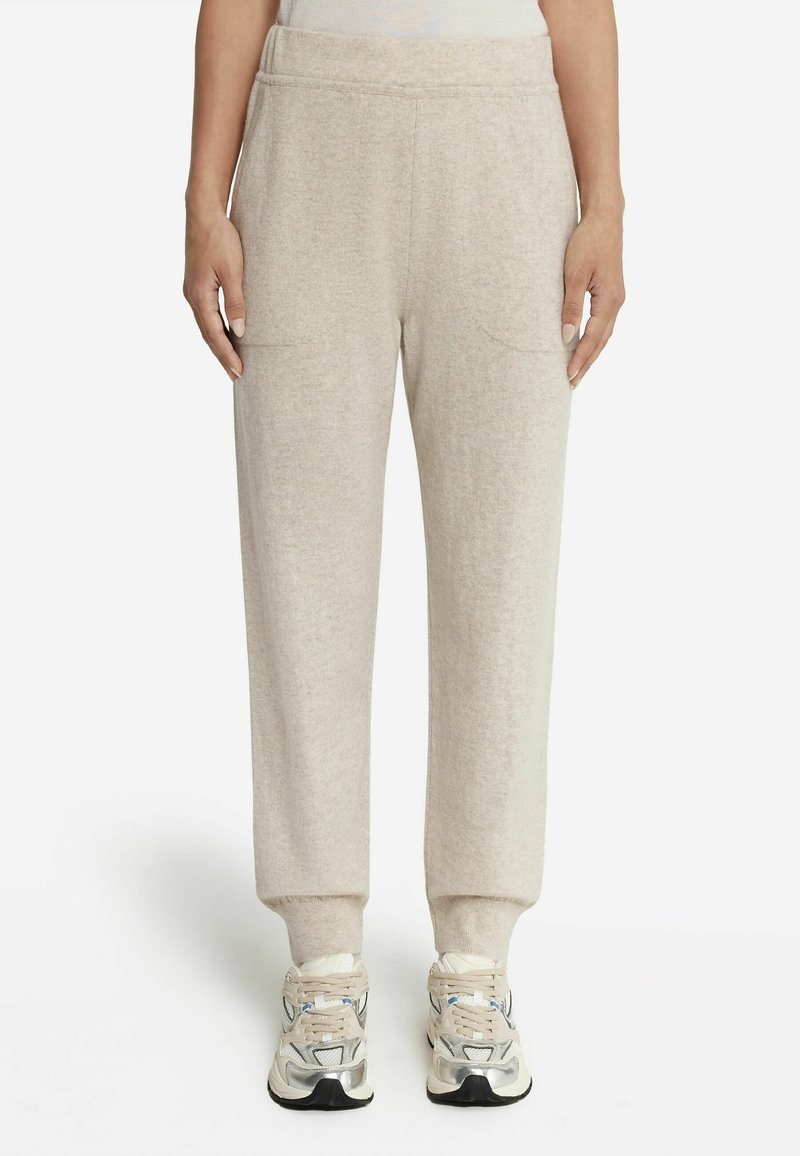 Beiga joggers i ullblandning med mjuk textur, elastisk midja, två framfickor och avsmalnande mudd. Kombinerat med silverfärgade träningsskor.