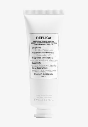 Hvit klemme tube merket "REPLICA" med svart tekst. Inneholder 50 ml parfymehåndkrem, duftbeskrivelse og merkevarenavn nederst.