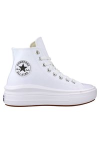 Bílé vysoké tenisky s gumovou podrážkou, s texturovaným povrchem, stříbrnými očky a kulatou nášivkou s logem na vnější straně.