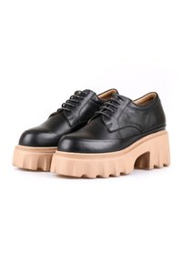 Chaussures en cuir noir avec une semelle épaisse beige, présentant un bout arrondi et un système de laçage classique pour un maintien sûr. Texture lisse sur l'ensemble.