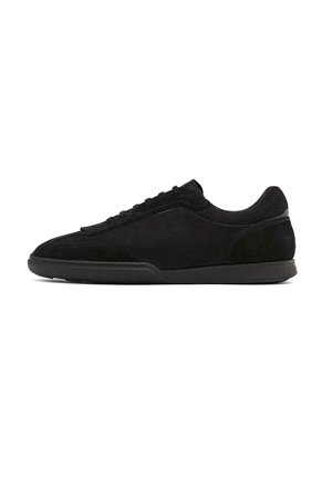 Czarne zamszowe sneakersy o gładkim wykończeniu, niskim profilu i teksturowanej gumowej podeszwie. Posiadają subtelne przeszycia i wyściełany kołnierz.