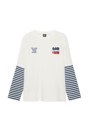 Chemise blanche à manches longues avec bas de manches rayés bleu et blanc, texte « NOUS PRENONS SOIN DE VOS MARCHANDISES » et motif coloré sur la poitrine.