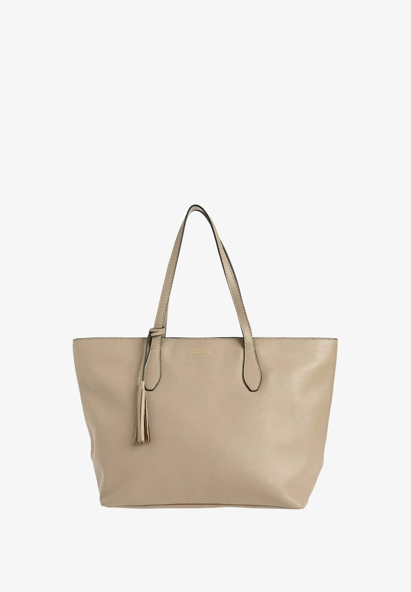 Sac fourre-tout en cuir beige avec deux poignées, présentant un détail de frange et des coutures foncées contrastantes le long des bords.
