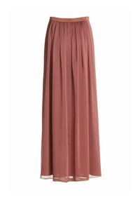 Jupe longue plissée rose poudré avec une taille haute et un tissu fluide, légèrement transparent, qui descend jusqu'au sol.