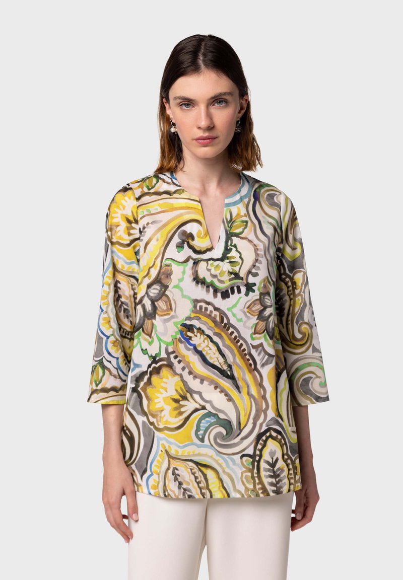 Blusa colorata e decorata in tessuto leggero. Presenta un scollo a V, maniche a tre quarti e motivi floreali in giallo, verde e marrone.