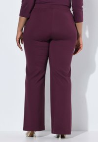 Donkerpaarse, wijde broek met een elastische tailleband, gemaakt van een zachte, gladde stof, met een strak afgewerkte zoom en zonder zichtbare details.