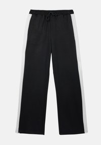 Pantalons de survêtement noirs avec des rayures blanches sur les côtés, fabriqués en matériau doux. Dotés d'une ceinture élastique avec un cordon de serrage. Design à jambes droites.
