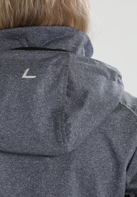 Grå fleecejakke med høj krave, justerbar hætte og et diskret logo på ryggen. Glat tekstur med et meleret mønster.