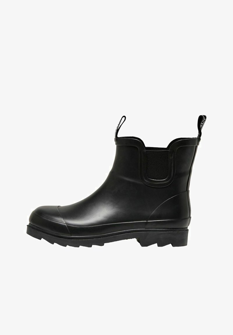 Bottine en caoutchouc noir avec des panneaux latéraux élastiques, des languettes de tirage, une semelle texturée et un bout arrondi. Surface lisse avec des détails subtils.