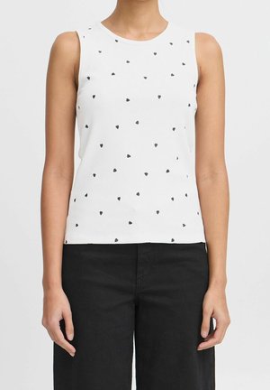 Weißes ärmelloses geripptes Top mit verstreuten kleinen schwarzen Herzmotiven, kombiniert mit hoch taillierten schwarzen Hosen.