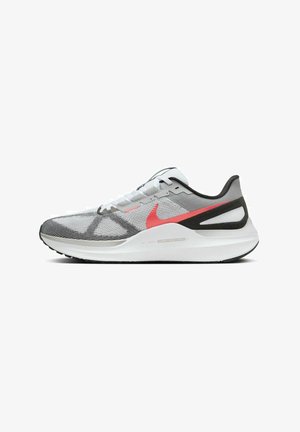 Las zapatillas de correr Nike cuentan con una parte superior de malla gris ligera con acentos en rojo y negro, una entresuela blanca acolchada y una suela exterior texturizada en negro.