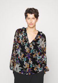 Blusa preta com padrão floral, apresentando um decote com babados, mangas longas transparentes, e padrões florais coloridos em roxo, laranja e azul-turquesa sobre um fundo escuro.