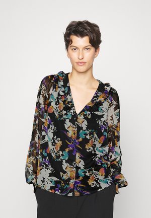 Blusa preta com padrão floral, apresentando um decote com babados, mangas longas transparentes, e padrões florais coloridos em roxo, laranja e azul-turquesa sobre um fundo escuro.
