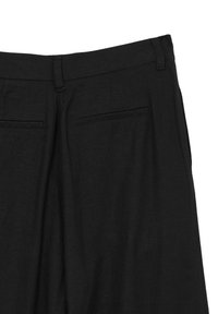 Schwarze Anzughosen mit Gürtelschlaufen und zwei hinteren Paspeltaschen auf einem weißen Hintergrund.