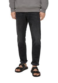 Gray sweatshirt, dark denim jeans, and black sandals. Jeans slightly tapered at the leg, sandals feature buckle detail on the strap.