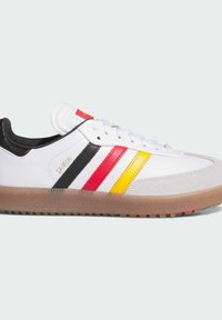 Hvid Adidas Samba sneaker med sorte, røde og gule striber, gummisål og snørelukning, vist i siden.