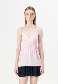 Pink sleeveless top with a v-neck, lace trim, gathered waist, layered navy skirt with ruffles, smooth fabric texture.