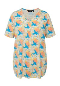 Camiseta de manga corta con cuello en V en color beige claro, con un patrón de zigzag colorido en rosa, azul y amarillo. Ajuste casual con tela suave y texturizada.