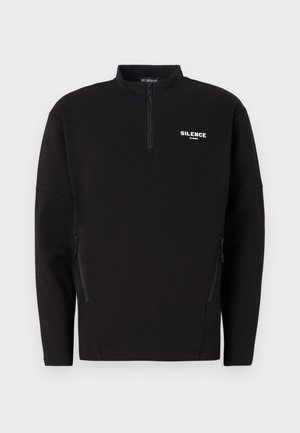 Mustan värvi pusakar, millel on pooltalje ja vetsuga küljetaskud ning rinnal valge "SILENCE" logo. Pehme kangas, mugav lõige.