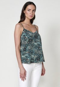 Camisola di raso in stampa leopardata teal e nera, con spalline sottili regolabili e una silhouette fluida. Tessuto liscio e leggero.