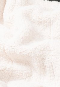 Tejido blanco texturizado y esponjoso con una superficie suave y aterciopelada, que exhibe un ligero brillo y un patrón consistente y uniforme en toda su extensión.