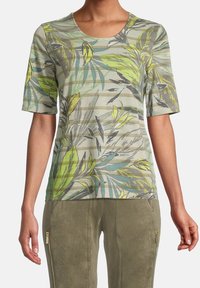 Kortärmad, rundhalsad skjorta i ljusgrön med ett tropiskt bladmönster och horisontella ränder. Mjuk, lätt tyg.