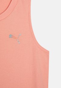 Breskva rebrasta majica bez rukava z okruglim izrezom i malim, reflektirajućim Puma logotipom s lijeve strane. Mekana tekstura i prilagodljiv dizajn.
