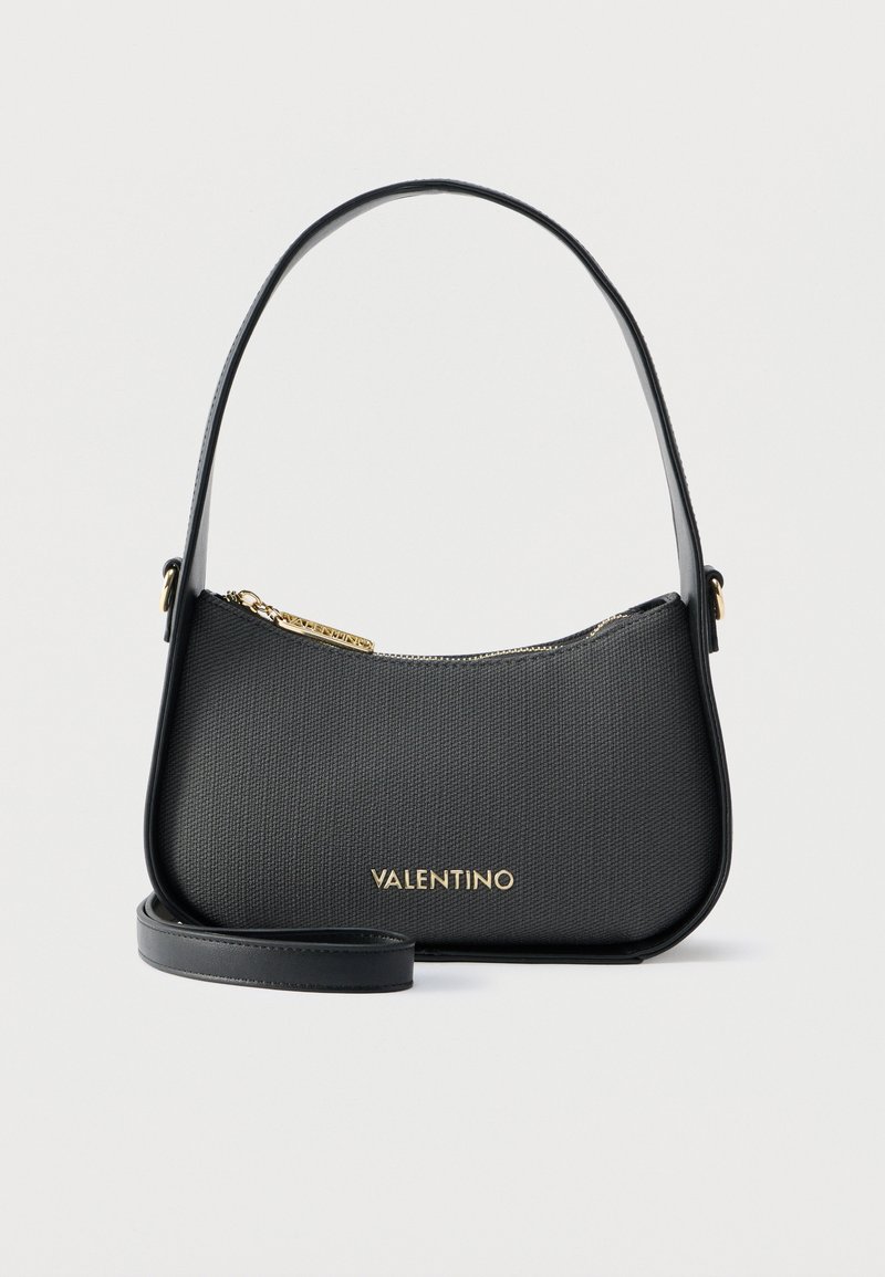 Μαύρη δερμάτινη τσάντα Valentino με χρυστό φερμουάρ και λογότυπο, με κοντό ιμάντα ώμου και αποσπώμενο μακρύτερο ιμάντα, σε λευκό φόντο.