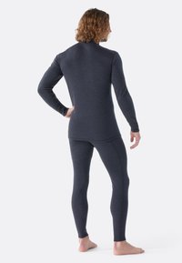 Set van thermisch ondergoed voor heren in donkergrijs, met een langmouwen top en aansluitende leggings, gemaakt van zacht, rekbaar materiaal met een gladde textuur.