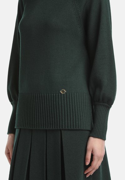 Pulover tricotat de culoare verde închis, cu tiv și mansete texturate. Are un mic accent de aur la talie. Materialul pare moale și texturat.