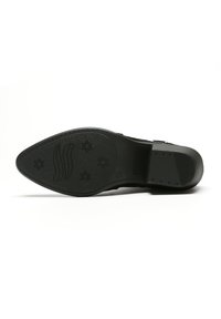 La suela de zapato negra presenta una forma puntiaguda con una superficie texturada, un logo en relieve y patrones de estrellas en la banda de rodadura. Bordes suaves y un diseño minimalista.