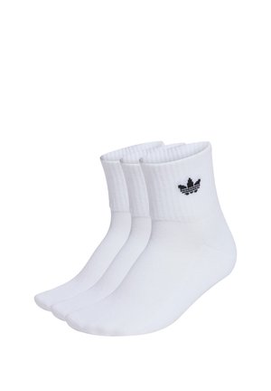 Tres pares de calcetines tobilleros blancos con puños acanalados que presentan un pequeño logo negro de Adidas trefoil en cada puño.