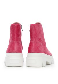 Botines de ante rosa con acabado texturizado, que presentan una suela blanca gruesa y cierre de cremallera lateral. No se aprecian detalles adicionales.