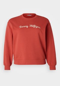 Sweatshirt rouge à col rond avec des poignets et un ourlet côtelés, présentant le texte "Tommy Hilfiger" brodé en blanc sur la poitrine.