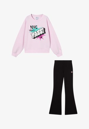 Pink sweatshirt with graphic text "NYC VIBES? YASS!" and black flared pants with small Champion logo on the side. Both made of soft fabric.