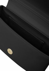 Portafoglio in pelle nera con più scomparti, caratterizzato da una texture liscia e un accento in hardware circolare dorato sulla parte anteriore.