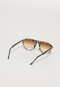 Ochelari de soare cu carapace de țestoasă, cu o formă rotundă, lentile maronii cu gradient și un cadru subțire, lustruit, cu un model floral delicat.