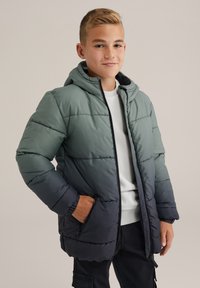 Vadderad jacka i gradientgrön till mörkblå, med huva, dragkedjestängning, ribbade ärmslut och två sidofickor. Strukturerad quiltad design.