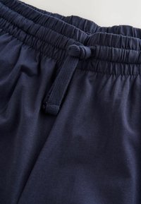 Pantaloncini con vita elastica blu navy e coulisse. Tessuto liscio e leggero, con un design semplice senza motivi o decorazioni.