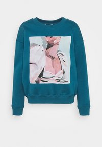 Tyrkysová mikina s kulatým výstřihem s potiskem ženy v bílém topu s nafouklými rukávy a perlovými doplňky.