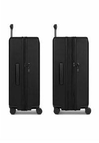 Valigia rigida nera con superficie strutturata, doppia cerniera, serratura a combinazione e quattro ruote per facilità di movimento. Include manico telescopico.